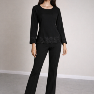 Model wearing Noir Embroidered Top in black with beaded hem and sleeves, long sleeve chiffon blouse, front view on off-white studio background