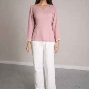 Model wearing Yara Pink Pearl Lace Top in blush pink crepe with pearl lace trim and flared sleeves, front view on neutral studio background